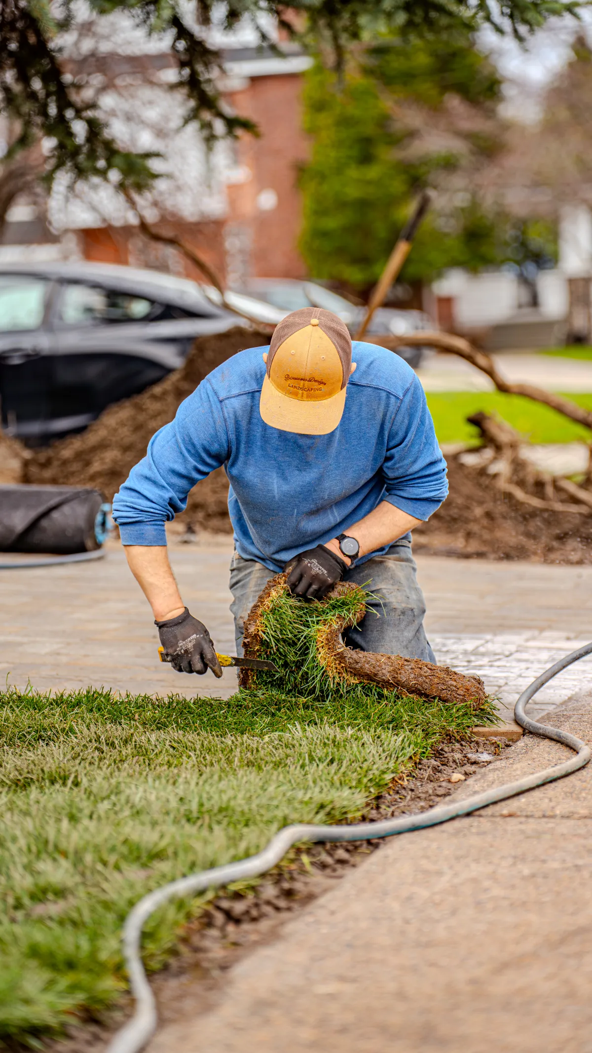 Bouwers crew member installing fresh sod beside a finished interlock driveway in North Bay.